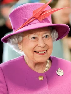 An image of Queen Elizabeth II in a pink hat and coat