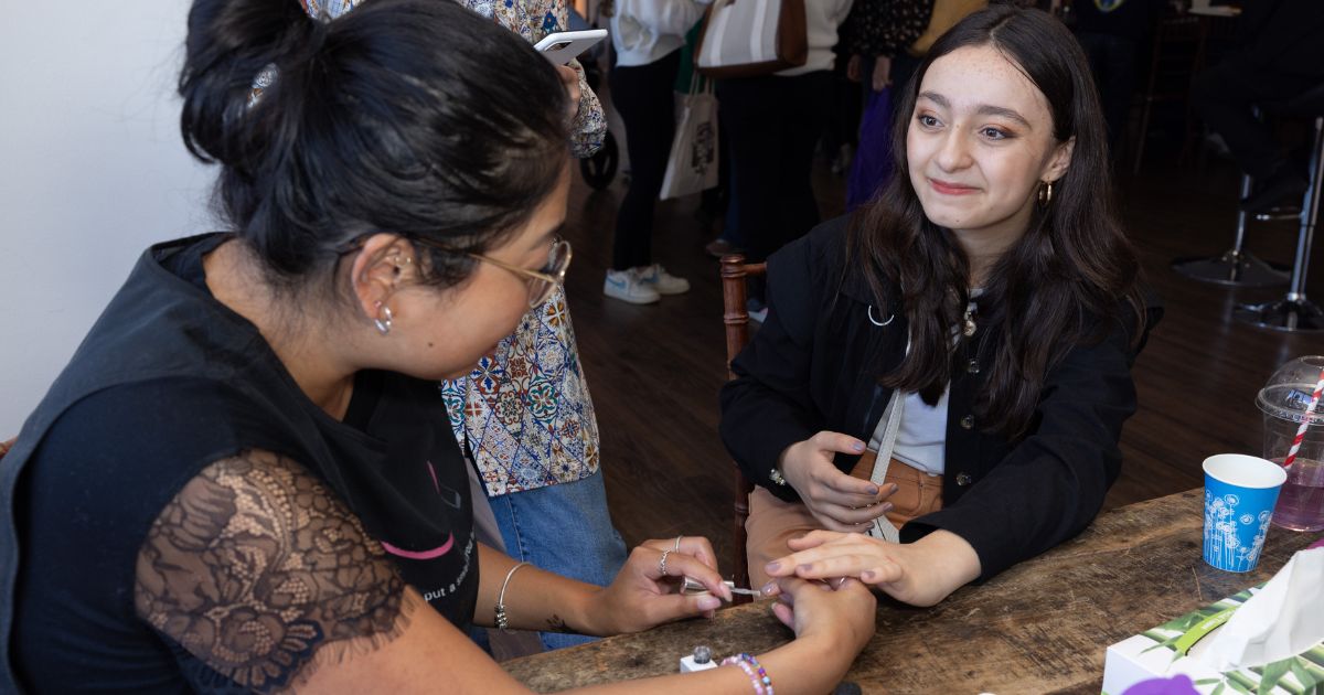 A woman doing a manicure for a teenage girl