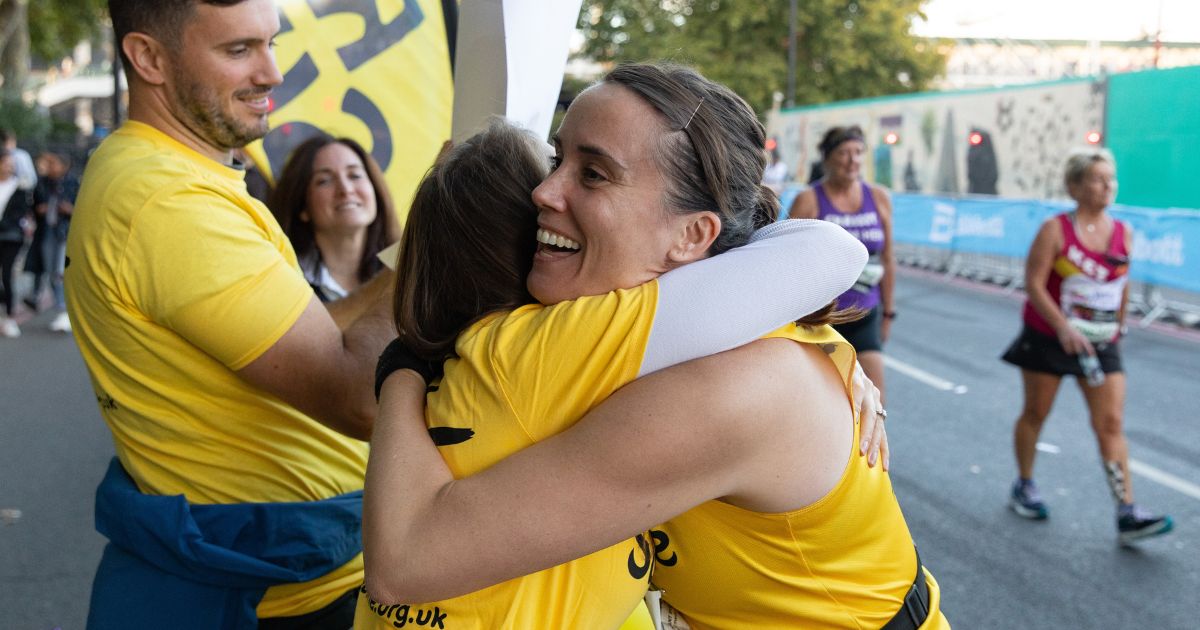 A Rays of Sunshine marathon runner hugging a supporter in the crowd