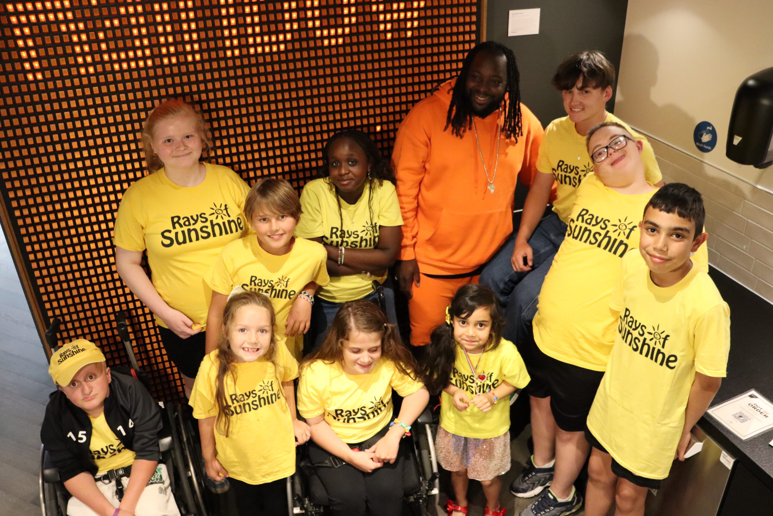 Aerial shot of group of children, all in yellow Rays of Sunshine t-shirts.