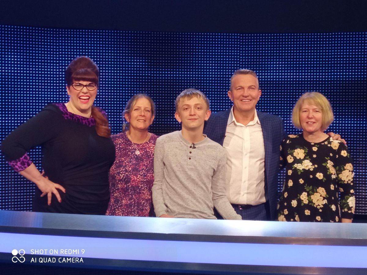 Five people stand together for a pic on the set of a gameshow