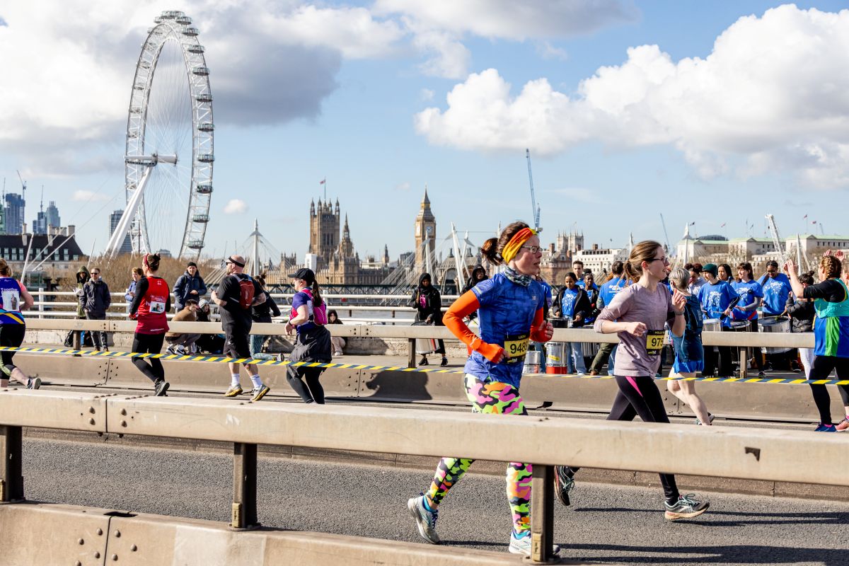 People running along the London Eye bridge