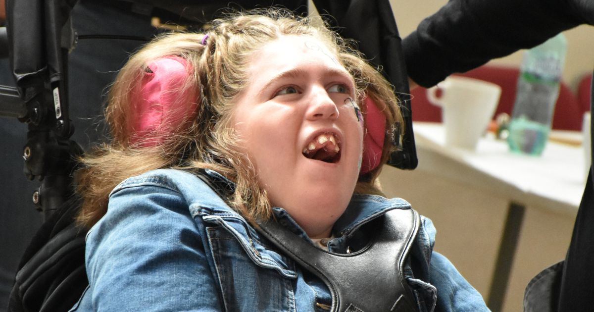 Close up photo of teen girl in wheelchair with head support