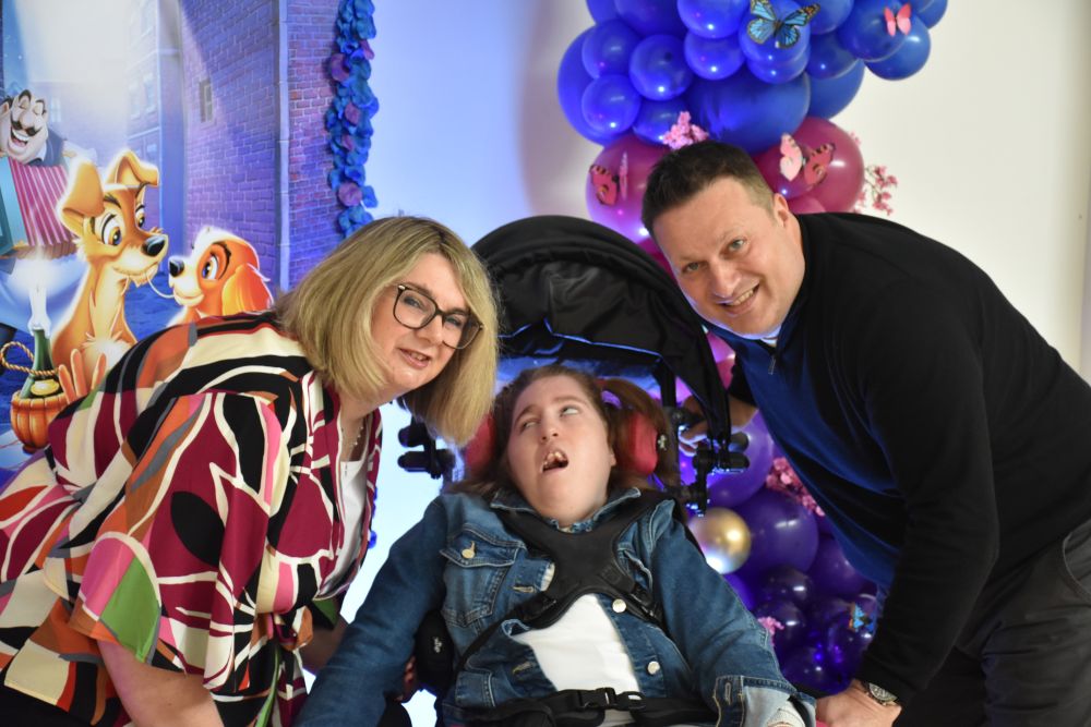 Teen girl in wheelchair with her parents