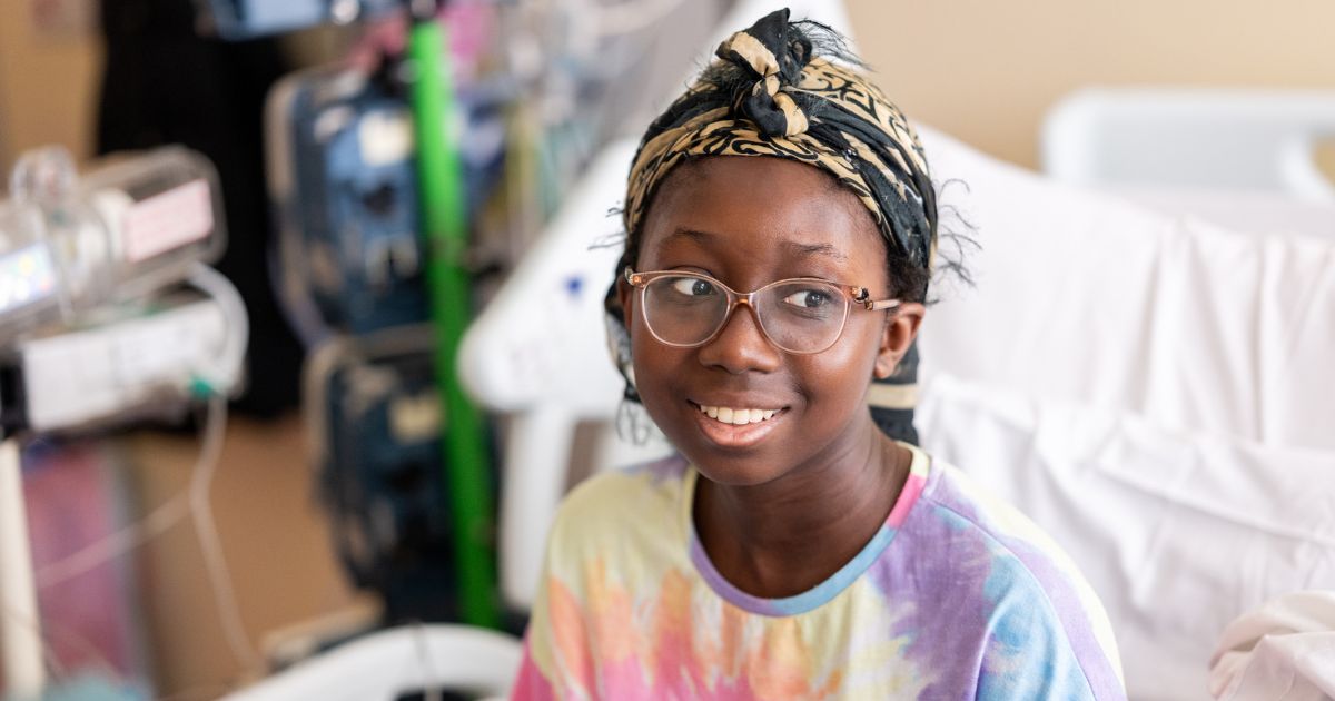 Teenager in hospital bed looking off to the side