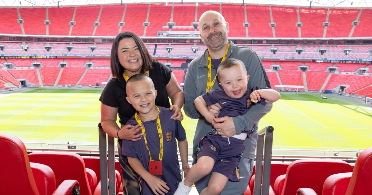 Family smiling to camera with Wembley Stadium in the background