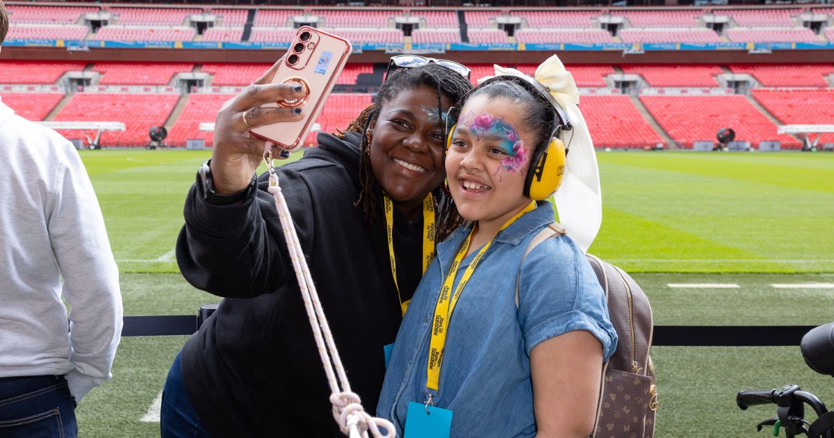 Mum and daughter taking selfie smiling with Wembley Stadium in the background