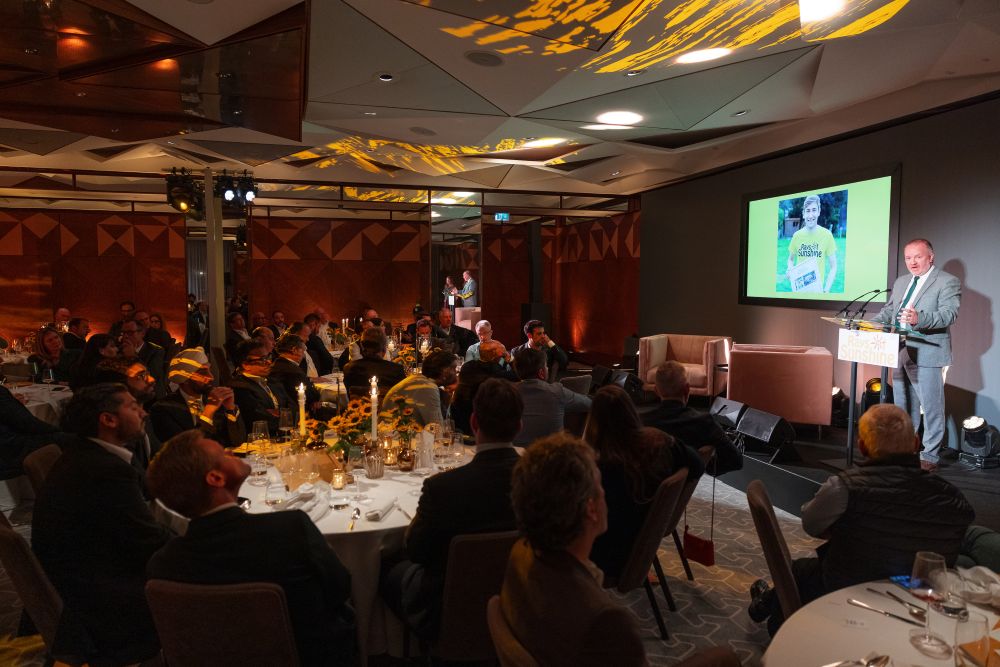 Man addresses full banquet hall of people