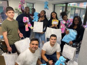 Group of volunteers holding teddy bears and bags
