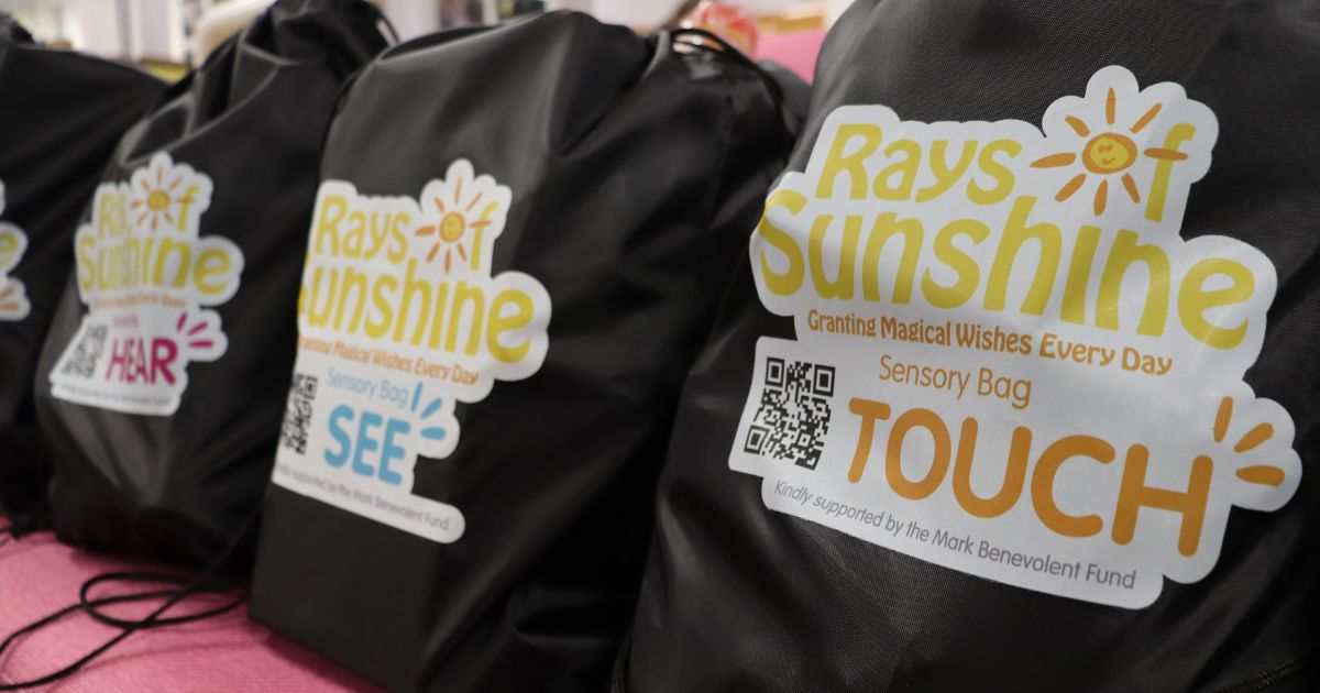 Line up of three drawstring bags which feature the Rays of Sunshine logo and are filled with sensory toys