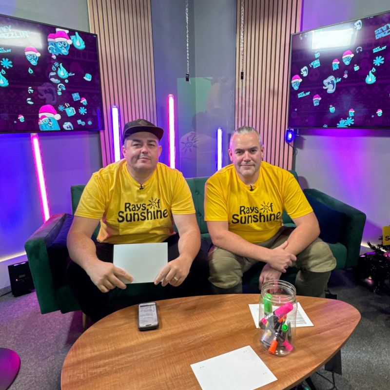 Two men wearing yellow Rays of Sunshine t-shirts